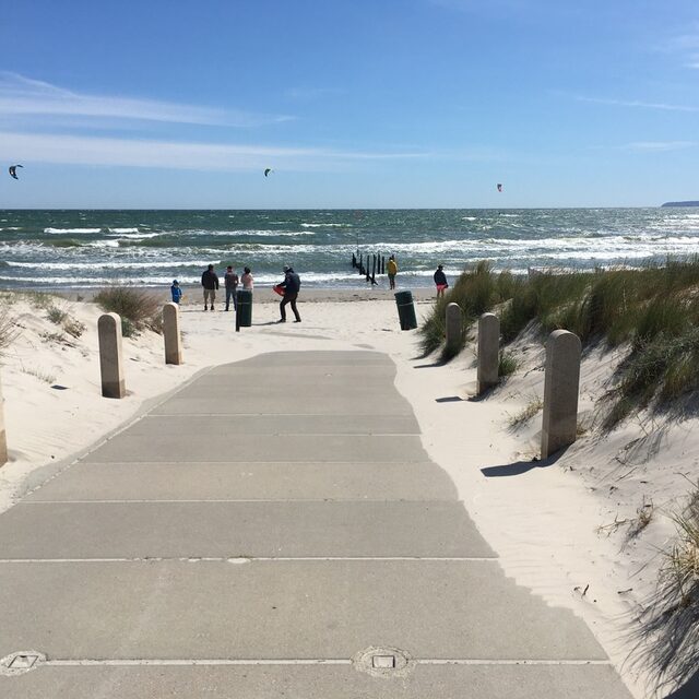 Bohlenweg und Promenade, die durch die Dünen hinunter zum Strand führen.