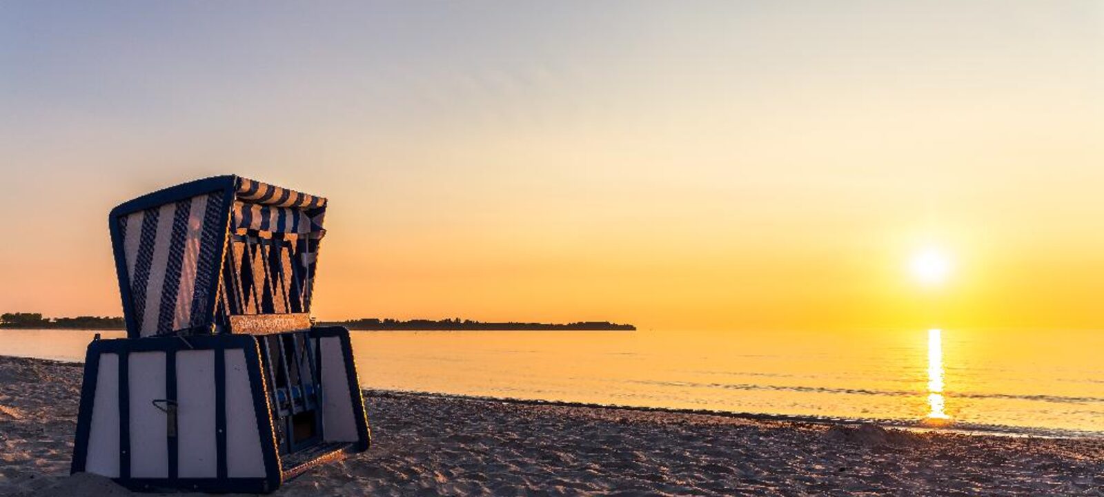 Strandkorb am Strand von Juliusruh bei Sonnenuntergang über der Ostsee.